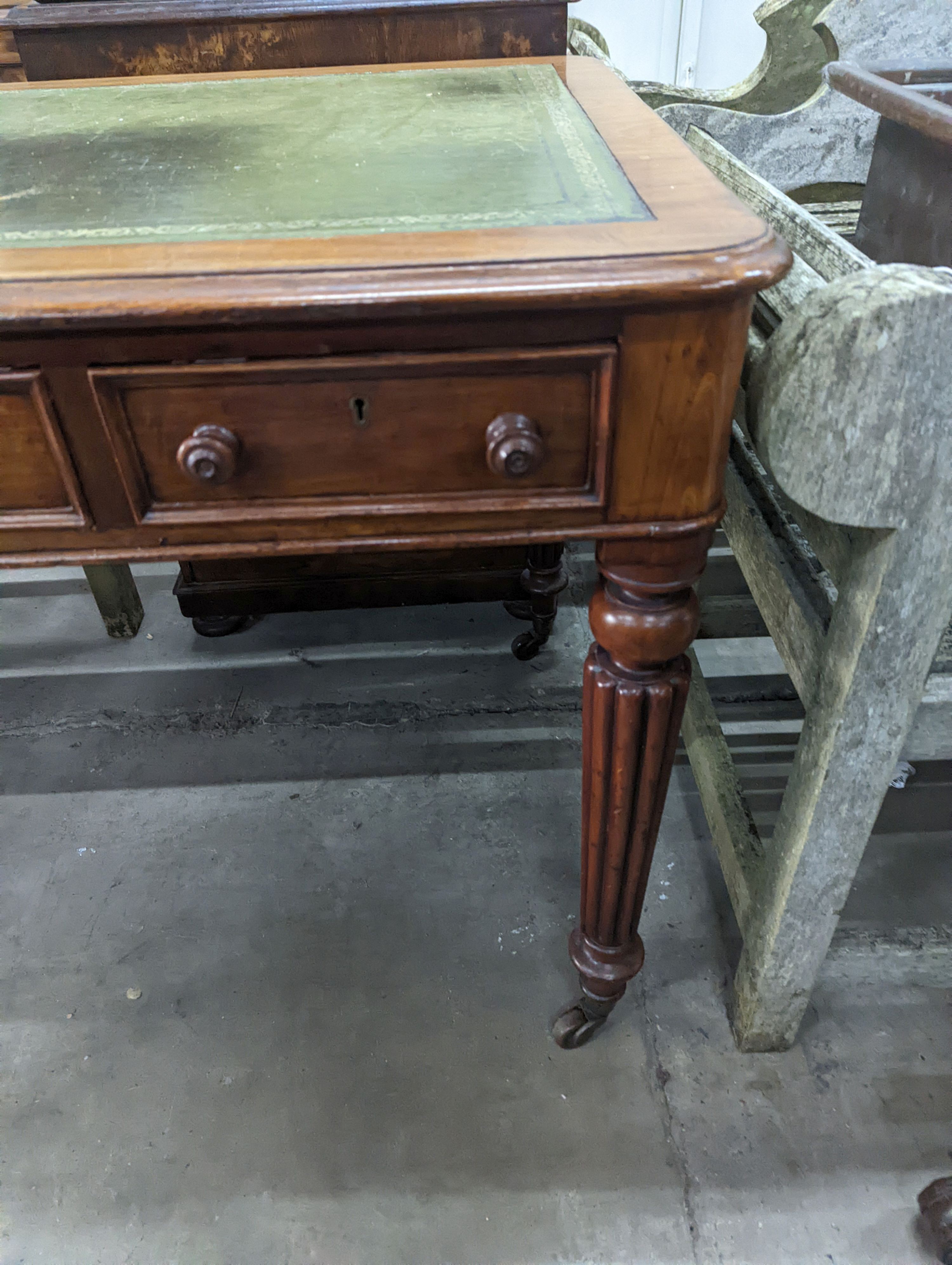 A Victorian mahogany three drawer writing table on fluted legs, width 106cm, depth 66cm, height 75cm